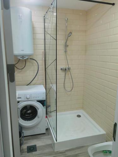 a shower stall in a bathroom with a washing machine at Studio Olimp Sea View Apartments in Olimp