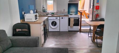 a kitchen with a washing machine and a microwave at Blue Moon Self Catering Accommodation in Dunkineely
