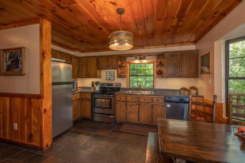 a kitchen with wooden cabinets and a stainless steel refrigerator at Hidden Pleasure by American Patriot Getaways in Cartertown