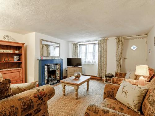 a living room with two couches and a fireplace at The Cottage in Wells