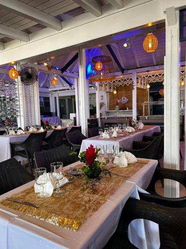 a dining room with tables and chairs and lights at Canella Beach Hotel in Le Gosier