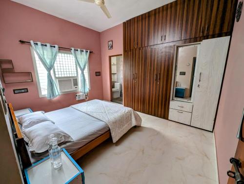 Vānivilāsa PuramにあるVilla 3 BHK - Asmitheのピンクの壁のベッドルーム(ベッド1台、テーブル付)