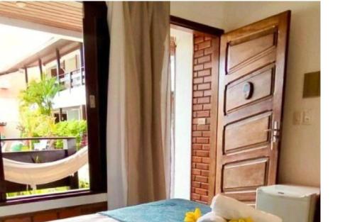 a bedroom with a door and a window with a balcony at Pousada Luz do Porto in Porto De Galinhas