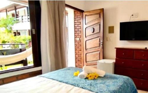a bedroom with a bed with two stuffed animals on it at Pousada Luz do Porto in Porto De Galinhas