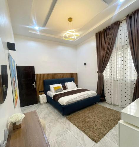 a bedroom with a blue bed and curtains at Abilene Shortlets in Rayfield