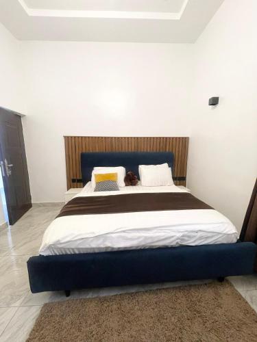 a bedroom with a large bed with a blue headboard at Abilene Shortlets in Rayfield