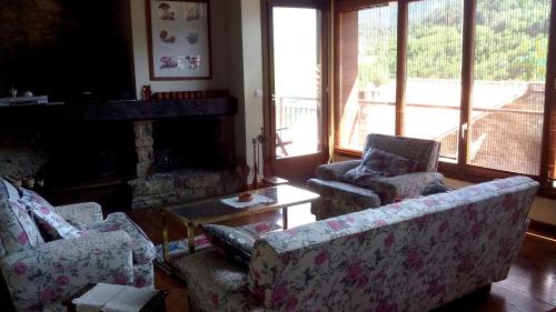a living room with two chairs and a fireplace at Casa Rural al Pirineu in Ansobell