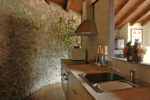 a kitchen with a sink and a stone wall at Casa Rural al Pirineu in Ansobell