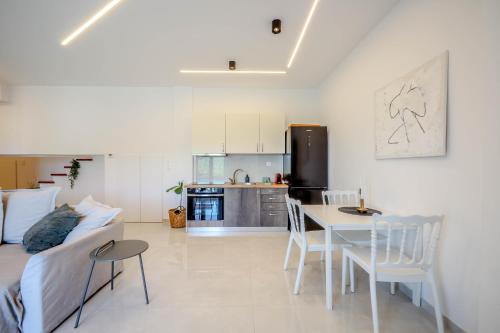 a living room and kitchen with a table and a couch at Oasis Acropolis Serres With Parking Next to Center in Serres