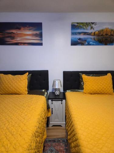 two beds in a room with yellow bedspreads at Brooklyn Luxury Suite in Brooklyn