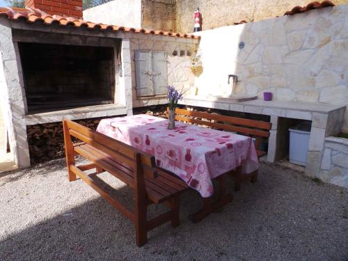 ein Tisch und eine Bank mit einer rosa Tischdecke darauf in der Unterkunft Apartment Kornic 3 in Kornić