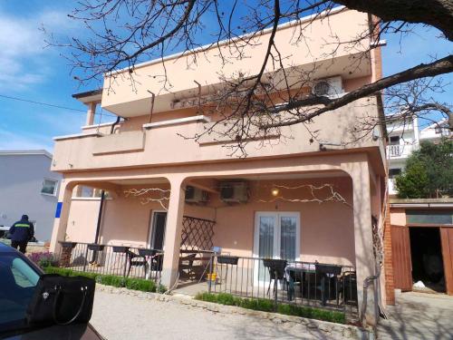 ein Haus mit einem Balkon mit Tischen und Stühlen in der Unterkunft Apartment Kornic 3 in Kornić