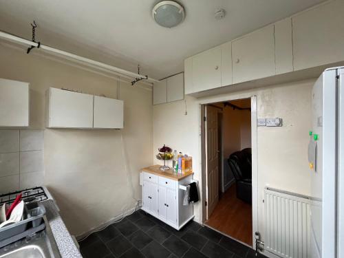 a kitchen with white cabinets and a black floor at Cozy Private Blackout Room in Longley