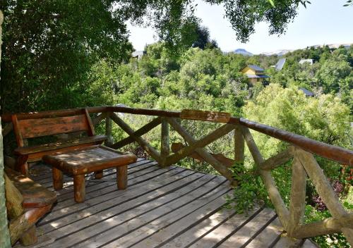a wooden bench sitting on top of a wooden deck at Aparts La Balconada by DOT Suites in Villa Pehuenia