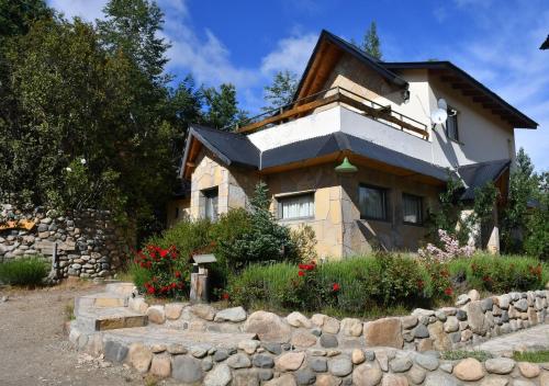 a house with a stone fence in front of it at Aparts La Balconada by DOT Suites in Villa Pehuenia