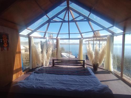 - une chambre avec un lit dans une pièce dotée de grandes fenêtres dans l'établissement Titicaca puma, à Puno