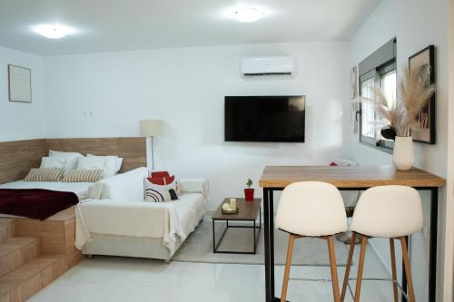 a living room with a bed and a table and chairs at Eléa Blu Pool & Garden in Afantou