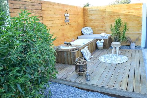 a wooden deck with a hot tub and a bench at Eléa Blu Pool & Garden in Afantou