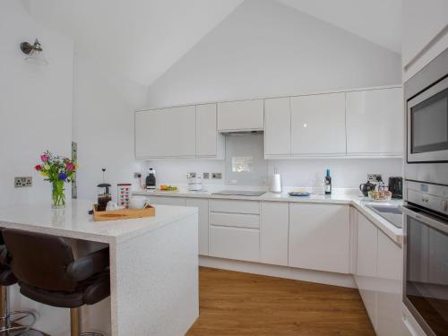 a white kitchen with white cabinets and a counter at Brens Barn in Bedale