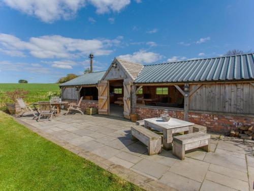a patio with a table and a building at Brens Barn in Bedale