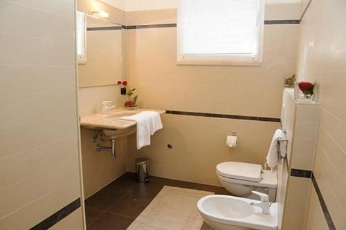 a bathroom with a toilet and a sink and a window at Villa Panoramica in Pozzolengo
