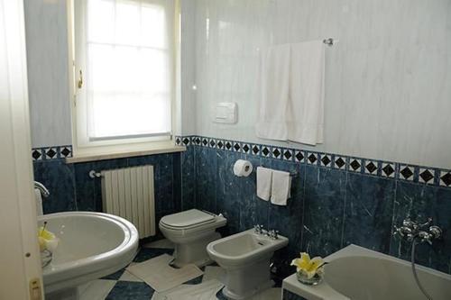 a bathroom with a tub and a toilet and a sink at Villa Panoramica in Pozzolengo