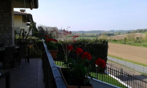 a balcony with red flowers and a fence at Villa Panoramica in Pozzolengo