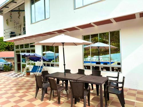 a table and chairs with umbrellas on a patio at Finca de descanso Brisas de Calandaima in Viotá