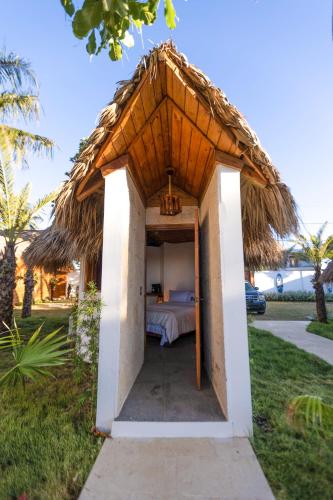 a smallbedroom with a bed in a grass roof at Serendipia Hotel Nizao in Nizao