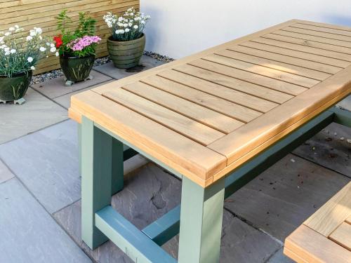 a picnic table with a green and blue bench at Seal View in Burnmouth