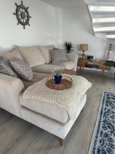 a living room with a couch and a table at The Boat Cottage - private beach access 