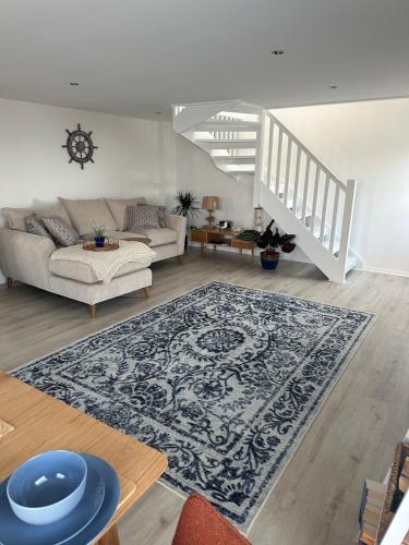 a living room with a couch and a rug at The Boat Cottage - private beach access 