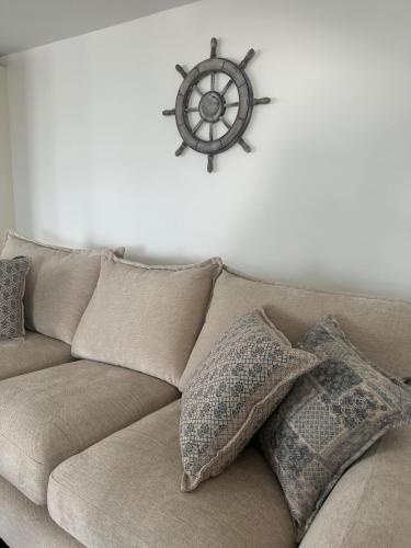 a brown couch with a steering wheel on a white wall at The Boat Cottage - private beach access 