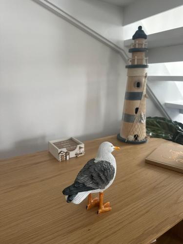 a toy bird sitting on a table next to a lighthouse at The Boat Cottage - private beach access 