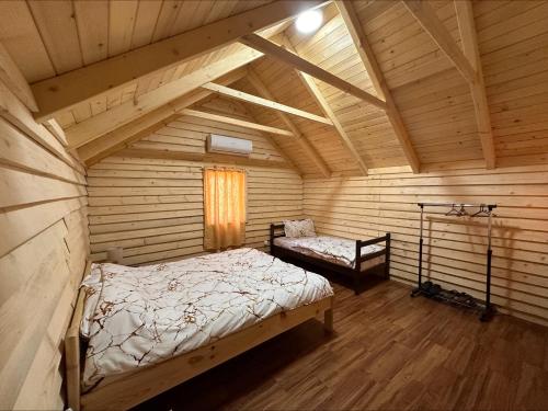 a room with two beds in a log cabin at Vidikovac Uvac in Družiniće