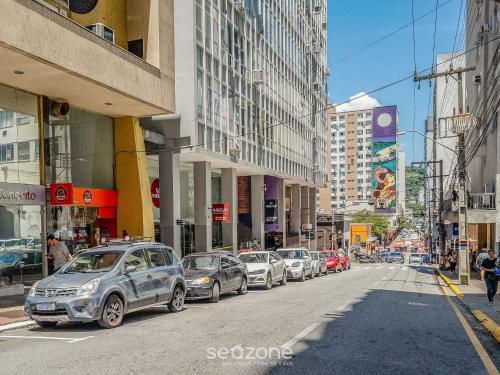 a line of cars parked on a city street at Aptos modernos no centro de Floripa - VLR in Florianópolis