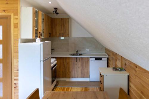 een keuken met een witte koelkast en houten kasten bij Apartman Filip in Kolašin