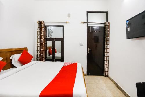a bedroom with a bed with a red blanket on it at Hotel O Devi Palace Inn in Gurgaon