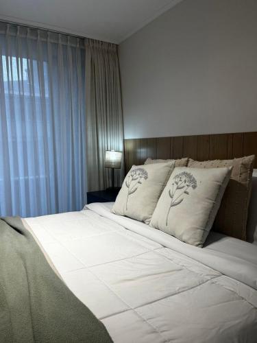 a bedroom with a large bed with white sheets and pillows at NM Departamentos Amoblados in Concepción