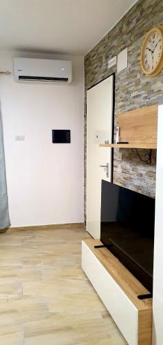 a living room with a clock on a brick wall at Appartamento Goloritzè in Lotzorai