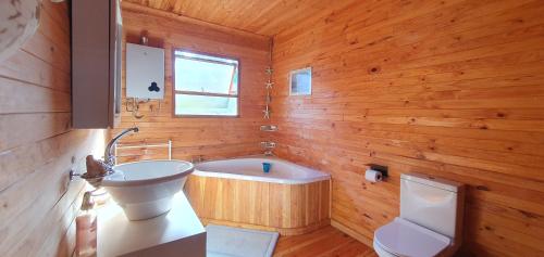 a bathroom with a tub and a sink and a toilet at Summer Villa in Mossel Bay