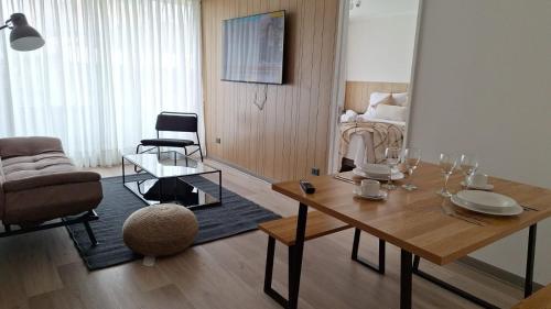a living room with a table with wine glasses on it at NM Departamentos Amoblados in Concepción
