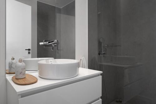 Un baño blanco con dos lavabos y una ducha. en Silver Coast Luxury Villa, en Reguengo Grande