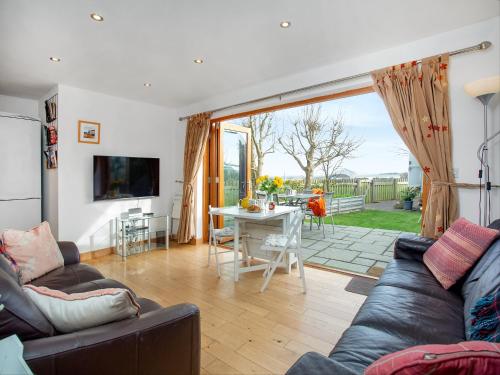 a living room with a couch and a table at Candles Cottage in Cubert