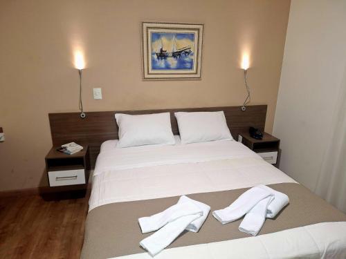 a bedroom with a bed with two white towels on it at Hotel Itapema in Valinhos