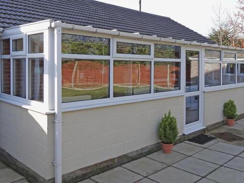 a conservatory with windows on the side of a house at Avalon in Grainthorpe