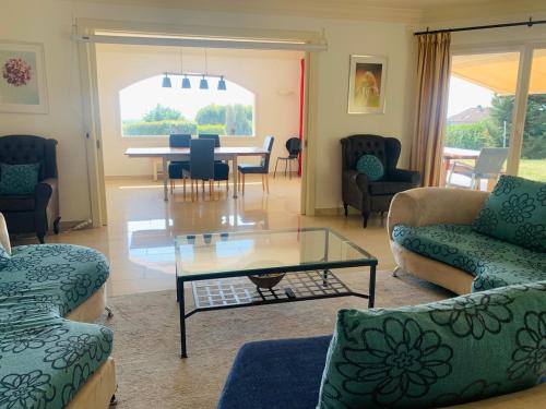 a living room with a glass table and chairs at 5 Bed Villa, 6 Baths, View and Beautiful Pool in Divonne-les-Bains