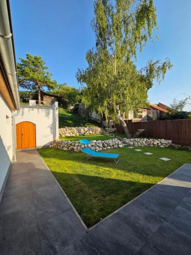 Apartmán Oáza pod Kopečkem في ميكولوف: فناء خلفي مع مقعد أزرق في العشب