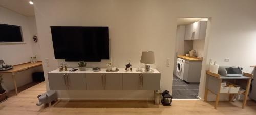 a living room with a flat screen tv on the wall at Blokhus - tæt på by og strand in Blokhus