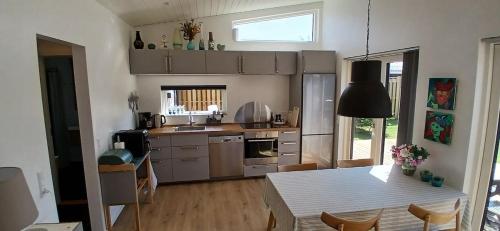 a kitchen with a table and a dining room at Blokhus - tæt på by og strand in Blokhus